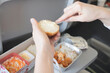 © Vladimir Razgulyaev - Airplane lunch close up: Womens hands butter a bun with a knife, Close-up of a womans hands buttering a bun with a knife during an airplane lunch, showcasing in flight dining and meal preparation