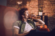 © Marko Geber - Man relaxing on couch drinking beer and listening to music