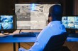 © Serhii - Back view of African American security operator use computer with screens showing surveillance camera footage