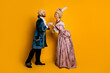 © deagreez - Elegant couple in royal-themed costumes posing together against a vibrant yellow background