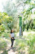 © VolodymyrNadtochii - Photographer girl stands with a camera on a strap around her neck in the garden