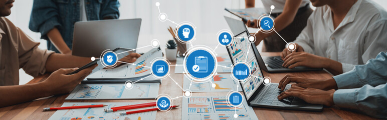 Fototapete - A diverse business team collaborates in a modern office, analyzing data and discussing strategies with laptops, charts, and digital tools, enhancing productivity and innovation. Amity