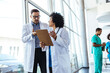© Dragana Gordic - Doctors in Discussion Reviewing a Clipboard in a Modern Hospital Setting