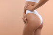 © New Africa - Young woman showing smooth skin after epilation procedure on peach color background, closeup. Space for text