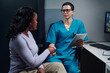 © pressmaster - Portrait of medical professional sitting in office holding a tablet, engaging with a patient. Healthcare setting with visible technology and medical devices in background