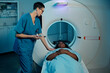 © pressmaster - Medical professional preparing patient for MRI scan in medical facility. Patient lying down on examination table, ready for diagnostic procedure involving MRI equipment