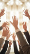 © Inspire Shots Hub - Close-up of multiple hands raised, wearing business attire, against a bright background, symbolizing teamwork, participation, and unity in a business or corporate setting