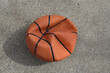 © mailcaroline - deflated basketball. business, economy, sports, life, or potential metaphor design element. looking down aerial view.  isolated on a concrete background.