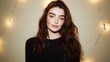 © Matt - Young woman with long wavy brown hair and black top smiling at camera with festive lights in background