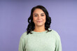 © Guillermo Spelucin - Confident latin woman smiling on purple background