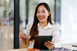 © David - Young fun smiling asian successful employee business woman work use hold tablet pc computer stand at workplace white desk modern office. Achievement career concept