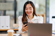 © David - Portrait of a happy Asian businesswoman using phone and work on laptop, Asian businesswoman working in modern office.