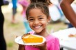 © InfiniteStudio - Child smiles while holding a slice of pumpkin pie during a festive outdoor gathering