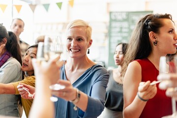 Wall Mural - group of diverse people at social event, raising glasses in a toast. diverse crowd enjoy celebration