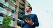 © BuyOutFelix01/peopleimages.com - Thinking, businessman and research with tablet in city, realtor and project for property development. Below, real estate agent and inspiration with smile for online review, listing website or walking