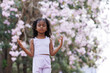 © kamonrat - A young girl meditates peacefully under pink cherry blossoms, eyes closed and hands in a serene pose. The calm atmosphere highlights mindfulness, relaxation, and a deep connection with nature.