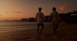 © peopleimages.com - Sunset, holding hands and couple with walking on beach, vacation holiday and bonding together for date. Back, man and woman with peace for love, travel adventure or connection space in relationship