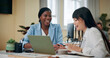 © peopleimages.com - Business women, laptop and laugh in office for feedback, advice or problem solving. Accountant team, collaboration or tech in agency for training, discussion and assistance with learning software