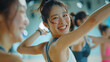 © Doraway - A woman happily dancing in a dance class at a gym studio.