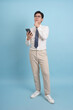 © Timeimage - Professional man in casual outfit looks thoughtful while using smartphone against blue background