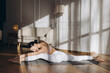 © anatoliycherkas - Young woman practicing yoga front splits pose at home