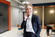 © muse studio - Businesswoman talking on the phone in a modern office space during a meeting