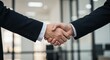 © GS-Studio - Agreement Handshake: Two business professionals in formal attire seal a deal with a firm handshake, symbolizing agreement, collaboration, and mutual respect.