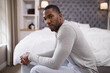 © wavebreak3 - Man sitting on bed at home, looking thoughtful and relaxed in bedroom