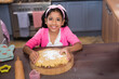 © wavebreak3 - Smiling girl baking dough at home, enjoying fun kitchen activity