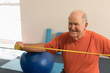© WavebreakMediaMicro - Elderly man exercising with resistance band, smiling and staying active at gym, copy space