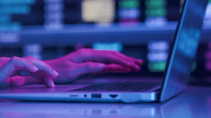 Close up shot of hands of unrecognizable worker using wireless laptop in neon lighting, time lapse