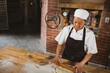 © Wavebreak Media - Female baker rolling dough on wooden table in rustic bakery kitchen, copy space