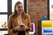© Wavebreak Media - Businesswoman holding coffee cup, discussing ideas in modern office workspace, copy space