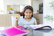 © Wavebreak Media - Young girl drawing with colorful markers at home, smiling and waving