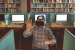 © Wavebreak Media - In library, man with VR headset at computer desk interacting with virtual world