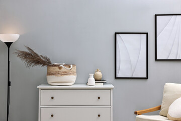 Poster - dresser, armchair and floor lamp near light grey wall in room. interior design