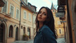 © Amar Tv - Young woman in denim jacket gazing over her shoulder in a quaint European street with vintage architecture