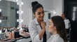 © GS-Studio - Makeup Artist in Action: A skilled makeup artist meticulously applies makeup to a client in a professional beauty studio, showcasing expertise and attention to detail.