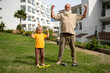 © sutulastock - Grandfather and grandson showing their strength after a workout session
