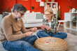© Miljan Živković - mature couple play cards while sit on floor and have fun at home