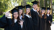© Михаил Решетников - Row of happy young people in graduation gowns outdoors. Students in the park.