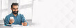 © Prostock-studio - Cheerful indian bearded man in blue shirt enjoys text on his phone as he takes notes with a pen in a bright, modern office setting