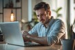 © Eti - Focused individual working on a laptop in a cozy welllit workspace