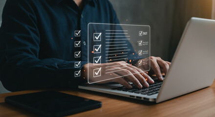 Wall Mural - a person using a laptop with a digital checklist overlay and a smartphone on the table near it