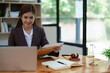 © Jirapong - female attorney advisor at a law firm reviews legal documents at her desk equipped with a laptop notebook and scales of justice in the office