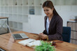 © Jirapong - female attorney advisor at a law firm reviews legal documents at her desk equipped with a laptop notebook and scales of justice in the office