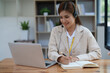 © Jirapong - Asian businesswoman wears a headset while participation in an online video conference discussing marketing and finance strategies effectively