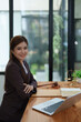 © Jirapong - female attorney advisor at a law firm reviews legal documents at her desk equipped with a laptop notebook and scales of justice in the office