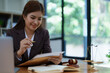 © Jirapong - female attorney advisor at a law firm reviews legal documents at her desk equipped with a laptop notebook and scales of justice in the office