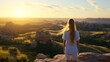 © ngamaz - Woman gazes at sunrise over a vast, rocky landscape